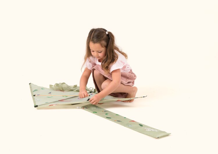 A kid repairing her kite